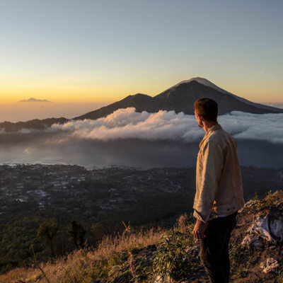 Man looking at Mount Batur at sunrise, Bali, Indonesia