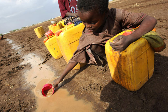 Kid in Africa filling water can